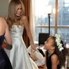Bride and Flower Girl look at each other Laughing, now in their dresses